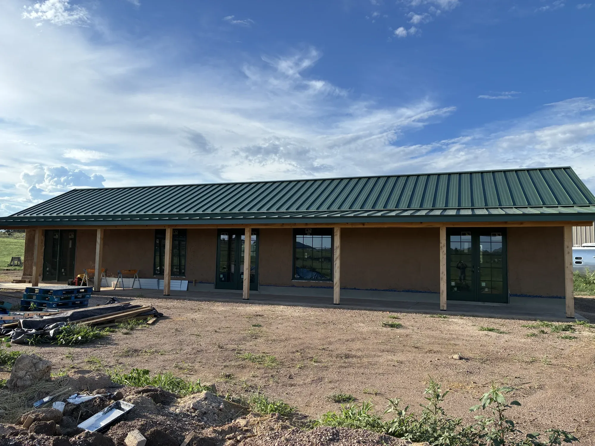 Green standing-seam roof over a long covered porch