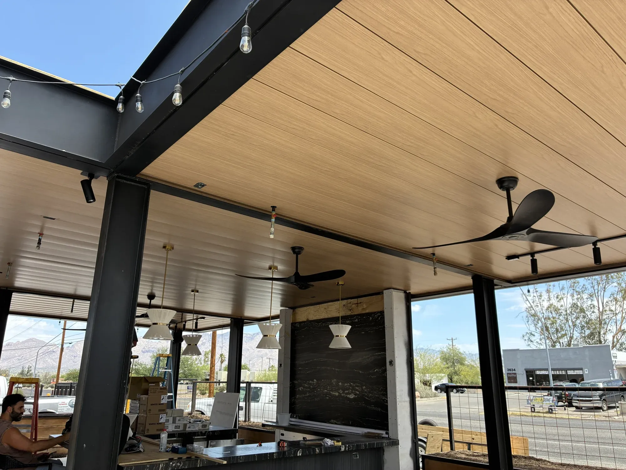 Finished wood-grain metal patio ceiling with dark beams