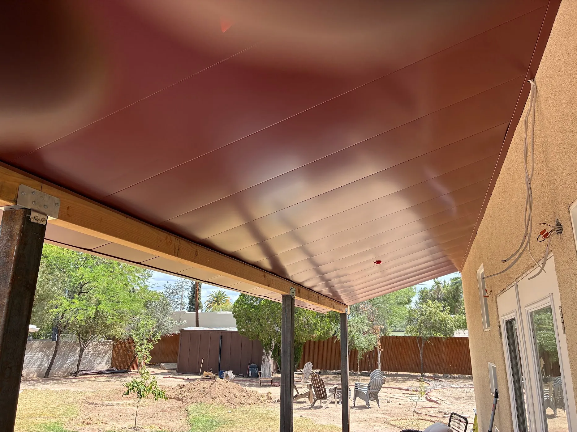 Finished red standing seam patio cover, full span underside view
