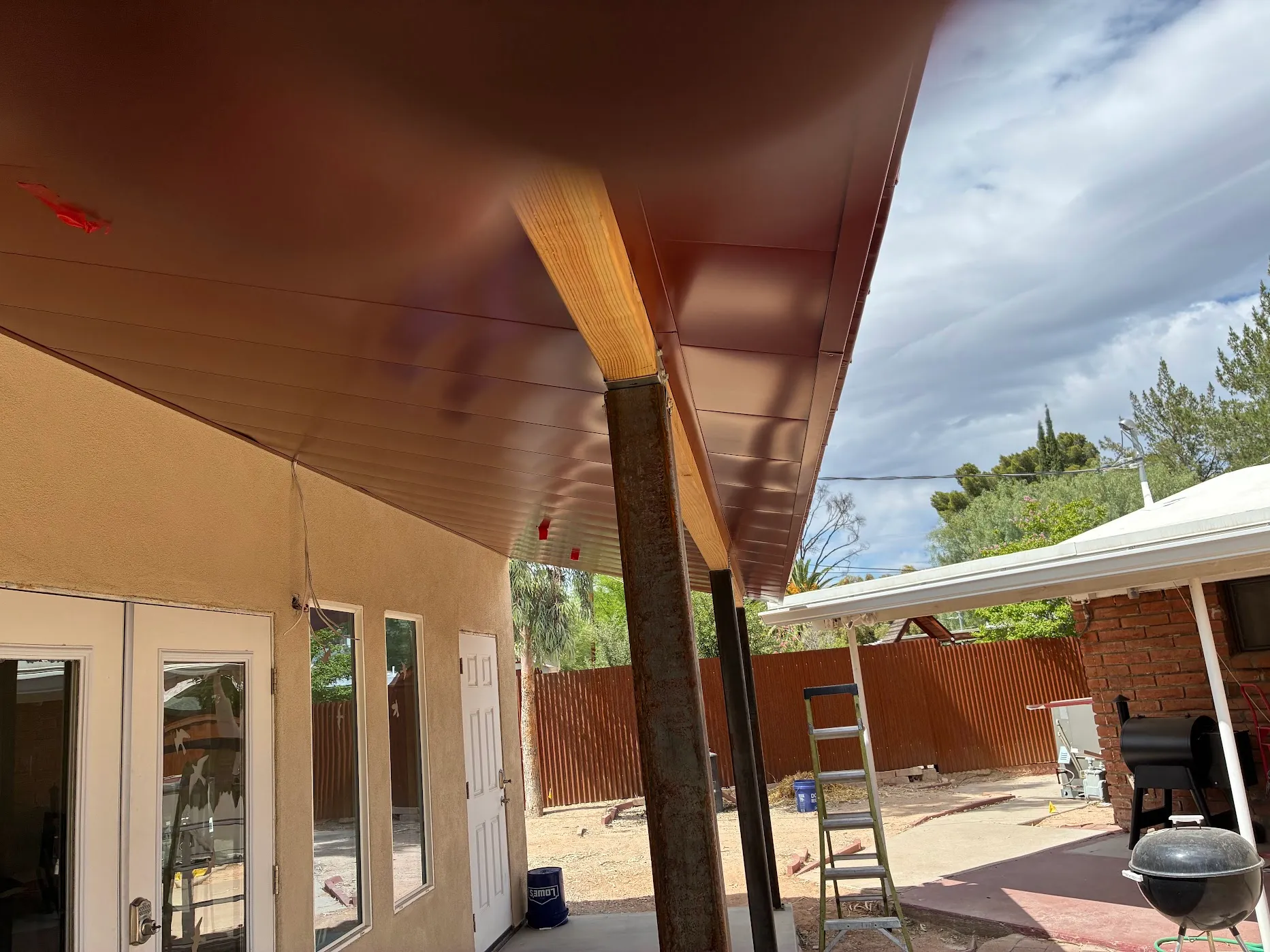 Finished red standing seam patio cover, full span view from underneath