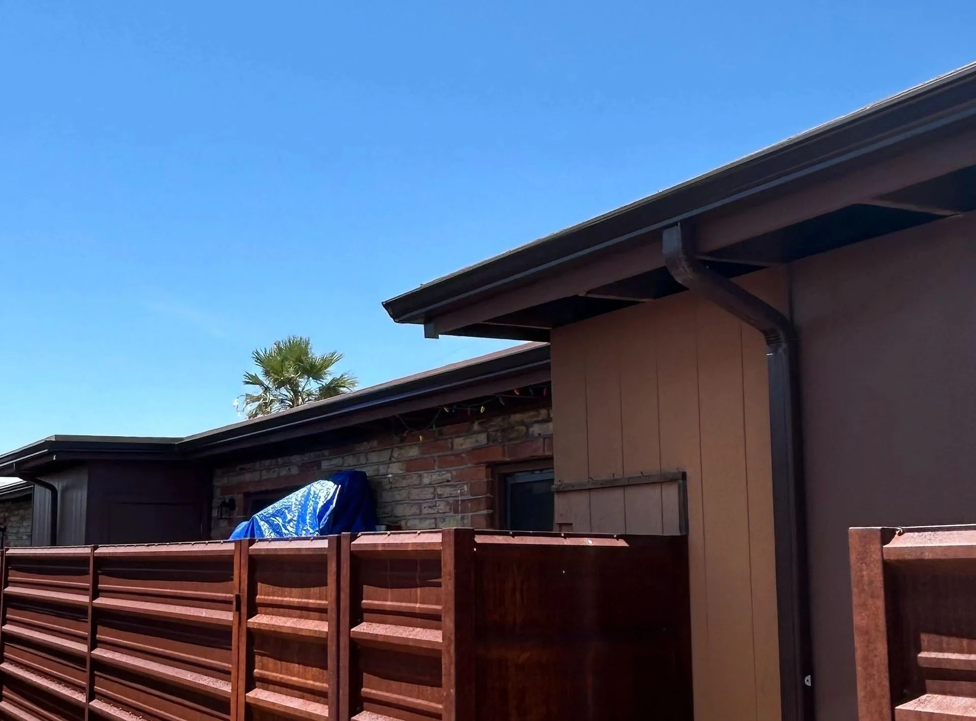 Custom brown brake-formed metal fascia and gutter detail on a Tucson home