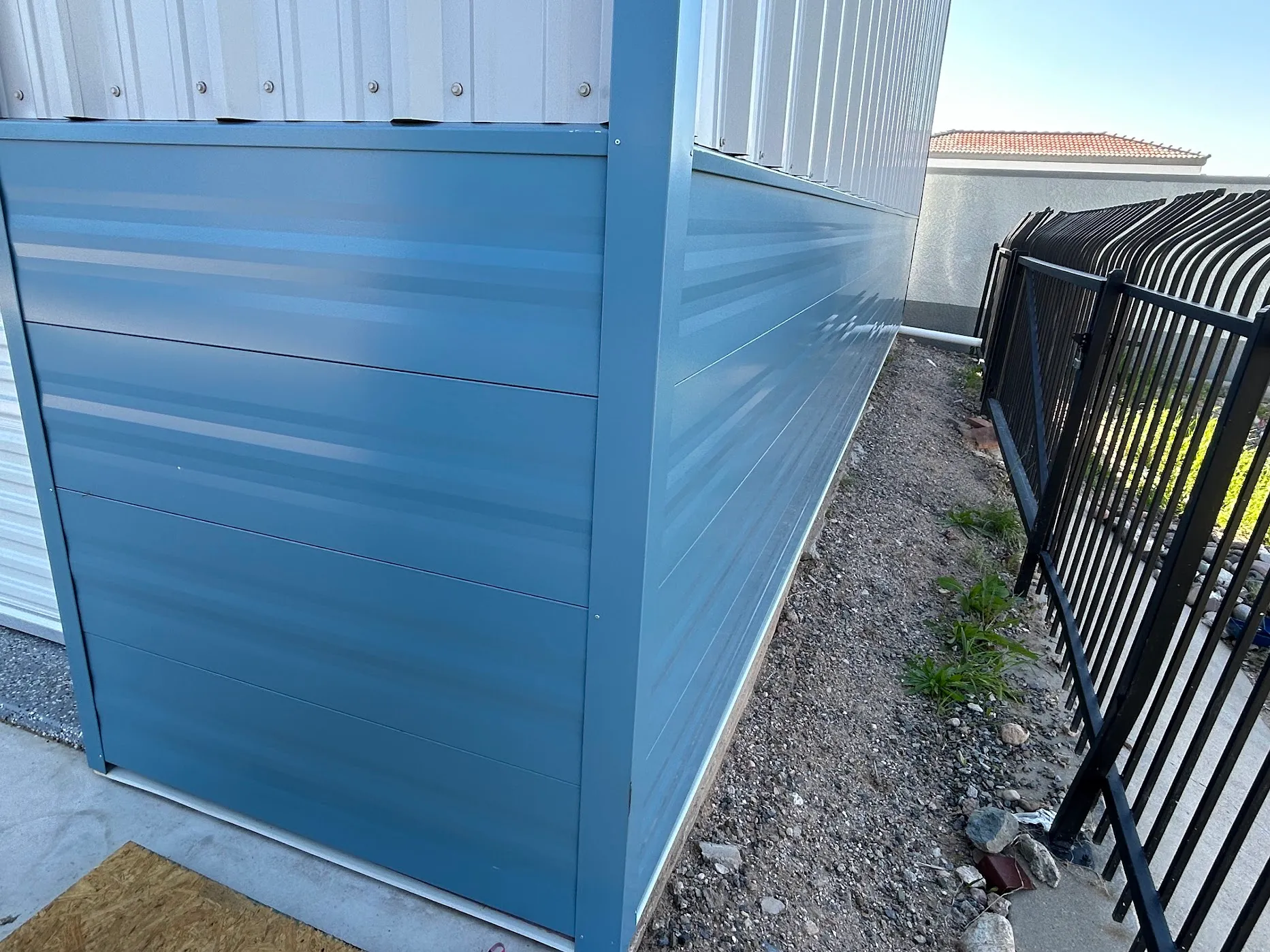 Detail of slate-blue horizontal-profile metal wainscot at a wall corner