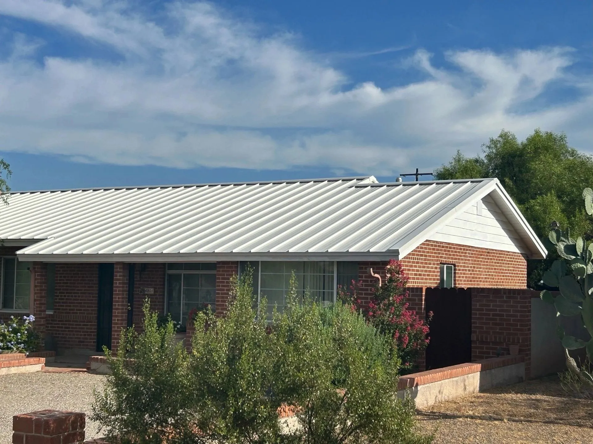 Arizona brick home with new white snap-lock standing seam metal roof